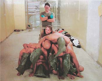 Spc. Charles Graner and Spc. Sabrina Harman with naked and hooded prisoners who were forced to form a human pyramid – a photo from Abu Ghraib prison in Iraq which is part of the evidence used against US soldiers accused of abusing and humiliating inmates, from: wikimedia